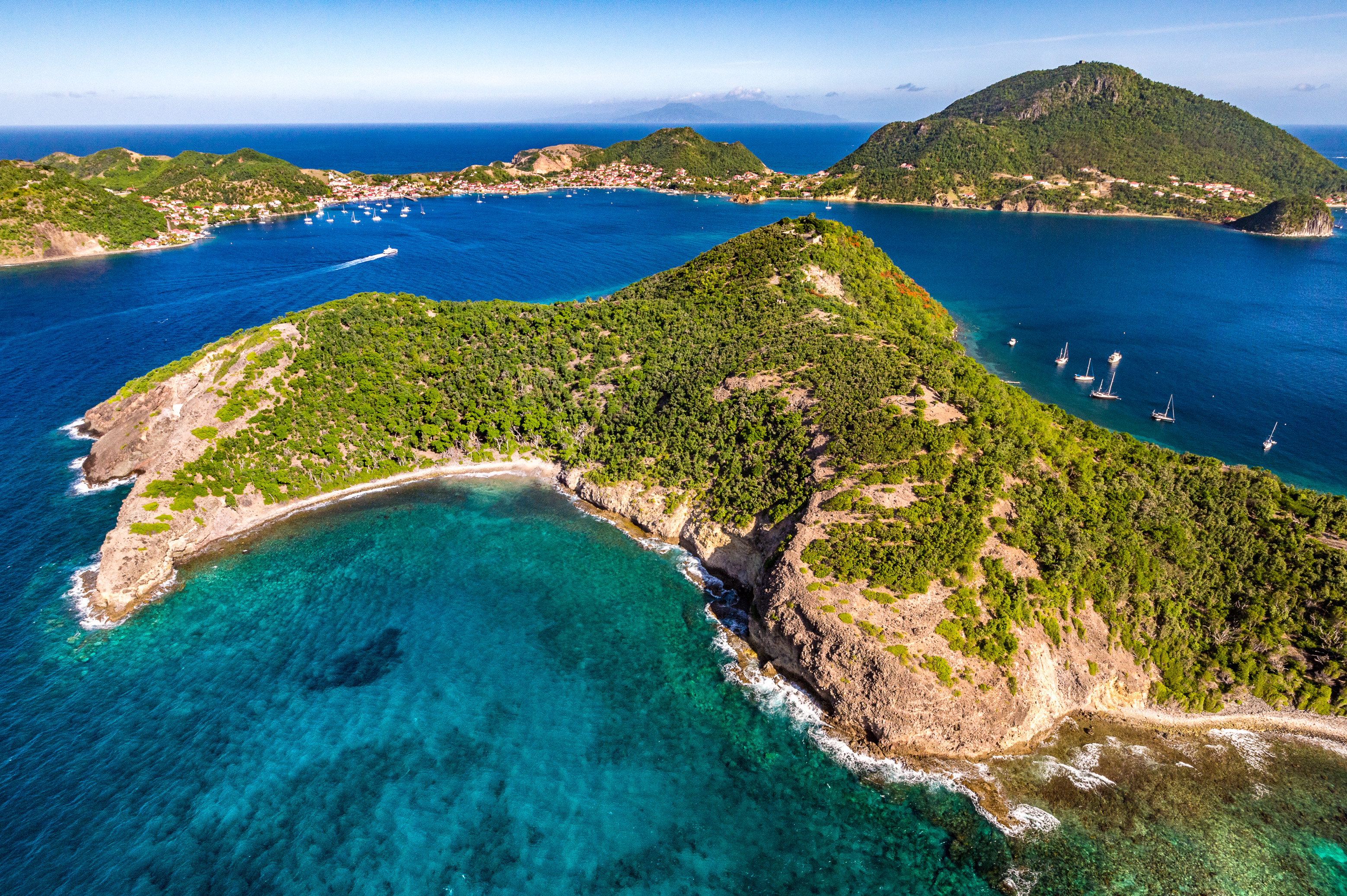 France, Caraïbes, Petites Antilles, Guadeloupe, Les Saintes, Terre-de-Haut, vue aérienne sur la baie du bourg de Terre-de-Haut, classée par l'UNESCO parmi les 10 plus belles baies au monde, la Dominique en arrière-plan // France, Caribbean, Lesser Antilles, Guadeloupe, Les Saintes, Terre-de-Haut, aerial view on the bay of the town of Terre-de-Haut, classified by UNESCO among the 10 most beautiful bays in the world, Dominica island in background