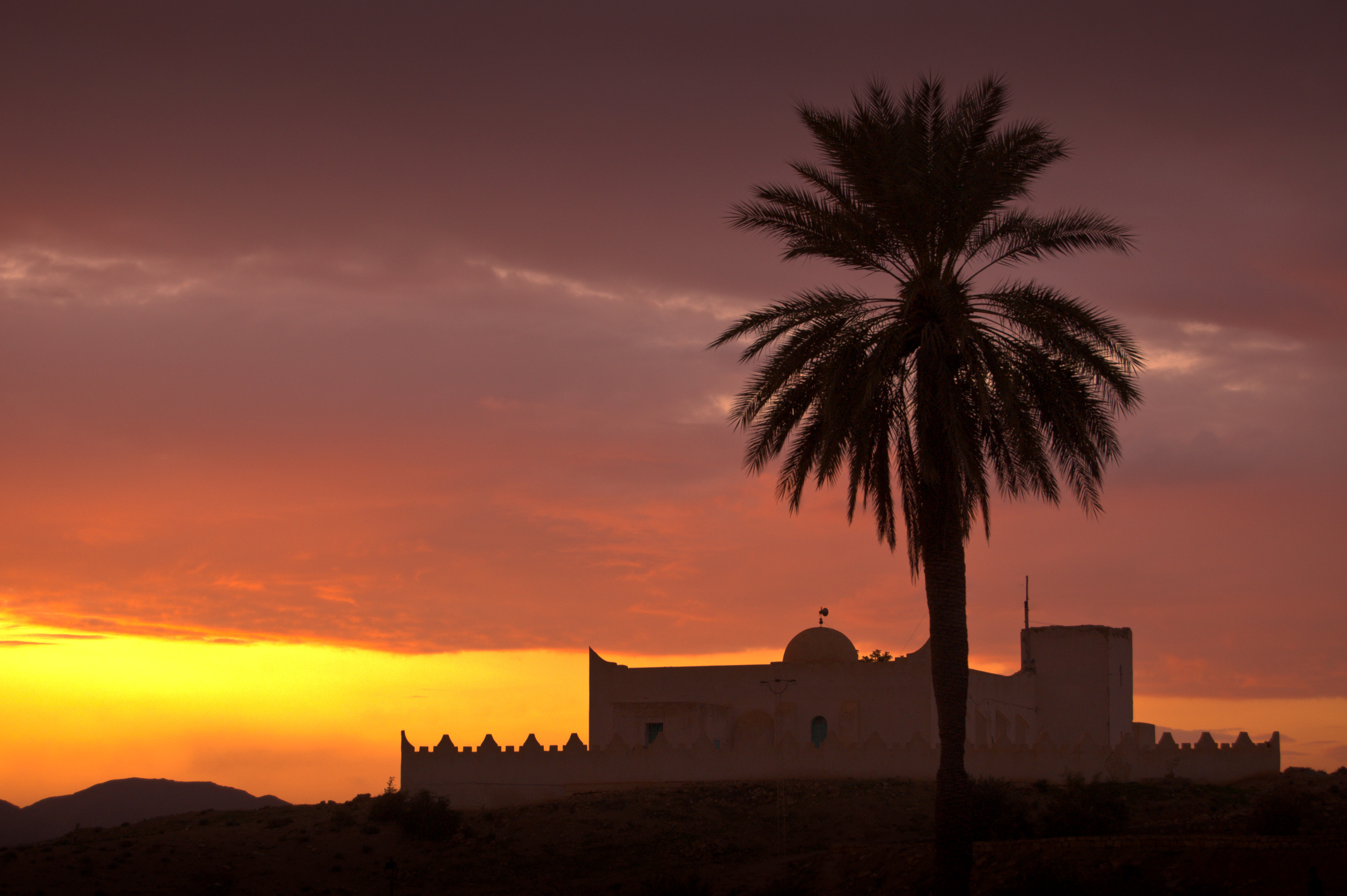 Tunisie, gouvernorat de Gabès, Matmata, mosquée de Matmata au soleil couchant avec un palmier, sud Tunisie // Tunisia, governorate of Gabès, Matmata mosque at sunset with a palm tree, southern Tunisia