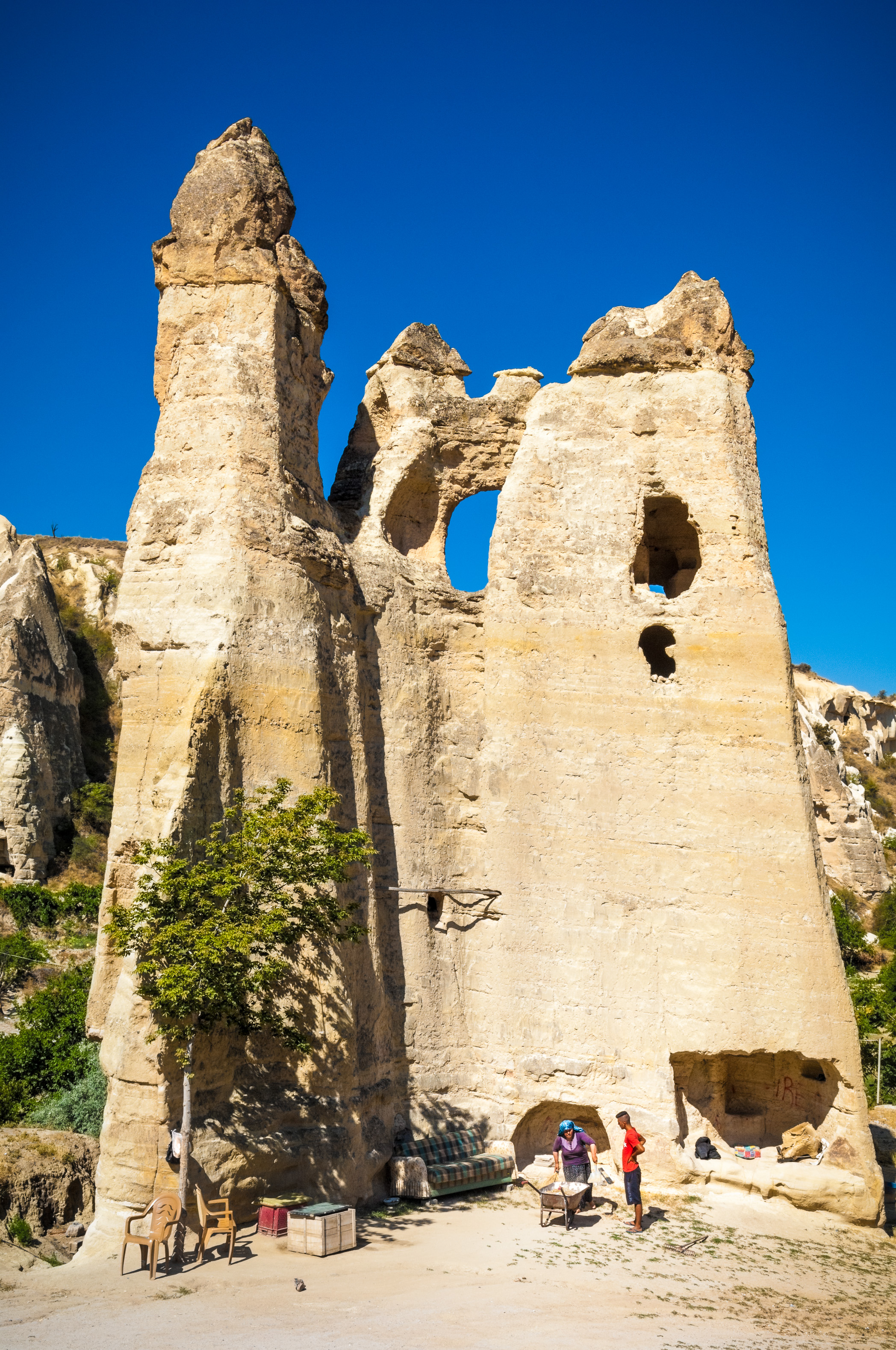 Turquie, Anatolie Centrale, province de Nevşehir, Cappadoce classée Patrimoine Mondial de l'UNESCO, Göreme, musée en plein air, couple travaillant au pied de cheminées de fées dans leur habitation troglodytique, Parc National de Göreme // Turkey, Central Anatolia, Nevşehir province, Cappadocia UNESCO World Heritage Site, Göreme, open-air museum, couple working at the foot of fairy chimneys in their cave dwelling, Göreme National Park