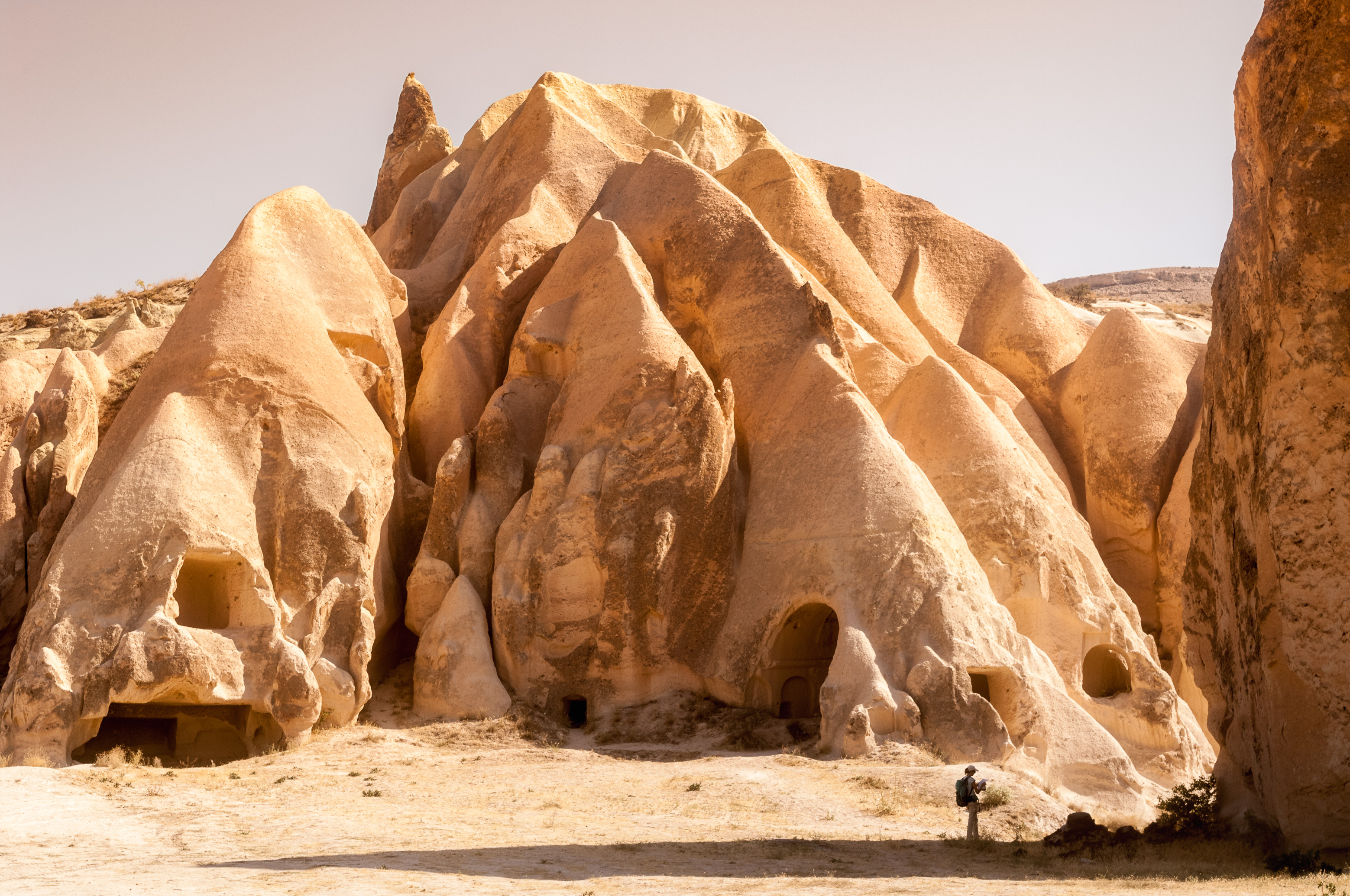 Turquie, Anatolie Centrale, province de Nevşehir, Cappadoce classée Patrimoine Mondial de l'UNESCO, Göreme, randonneuse dans la Vallée Rose, paysage de collines de tuf volcanique, cheminées de fées et vestiges d'habitations troglodytiques dans le Parc National de Göreme // Turkey, Central Anatolia, Nevşehir province, Cappadocia UNESCO World Heritage Site, Göreme, hiker in the Rose Valley, landscape of volcanic tuff hills, fairy chimneys and vestiges of troglodyte dwellings in the Göreme National Park
