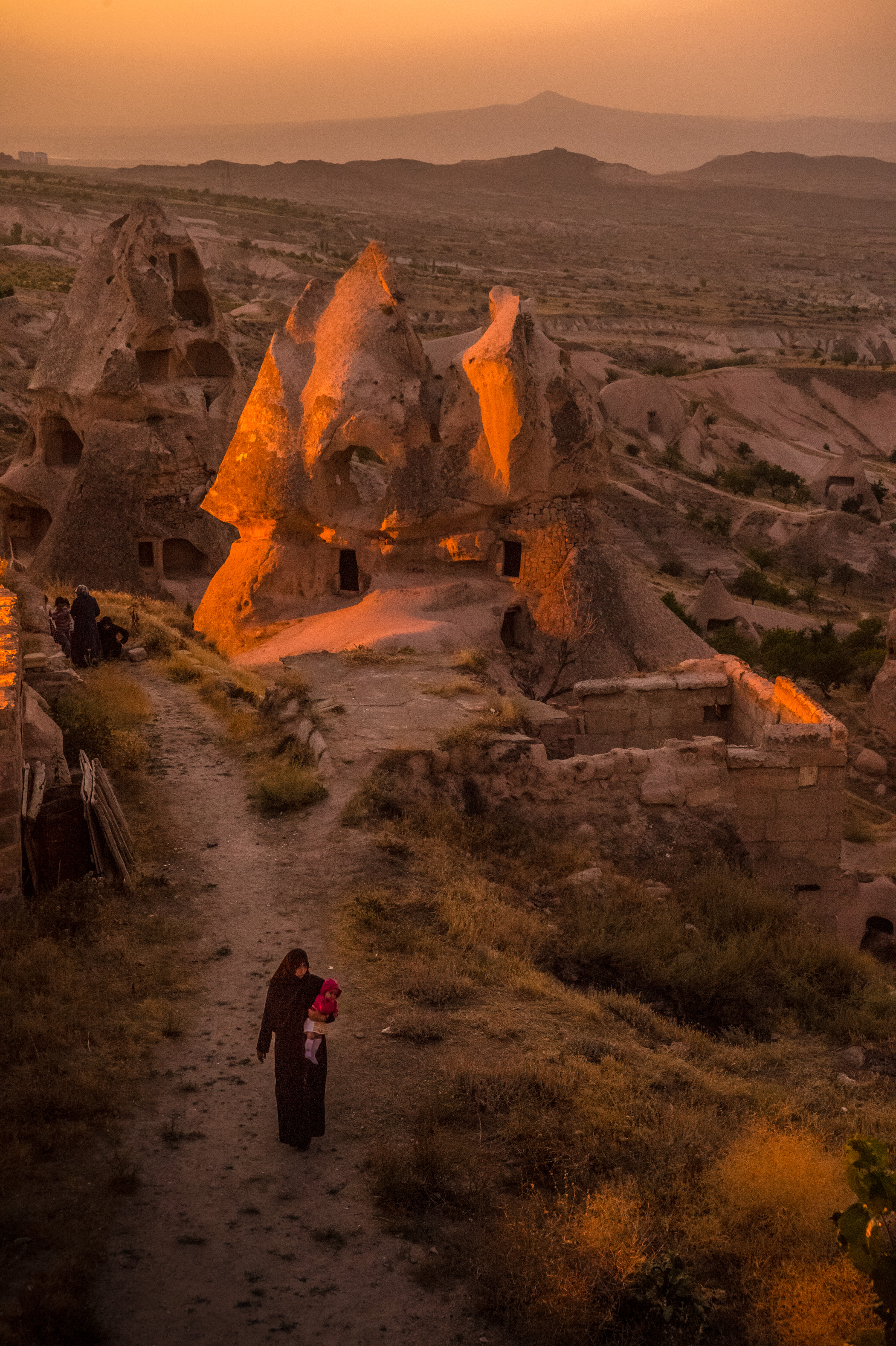 Turquie, Cappadoce, Uçhisar, Parc national de Göreme et sites rupestres de Cappadoce inscrits au  patrimoine mondial de l'Humanité par l'Unesco, une mère et sa fille rejoignent leur maison troglodyte au village d'Uçhisar au coucher du soleil // Turkey, Cappadocia, Uçhisar, Göreme National Park and the Rock Sites of Cappadocia World Heritage of Humanity by Unesco, a mother and daughter join their cave house in the village of Uçhisar at sunset
