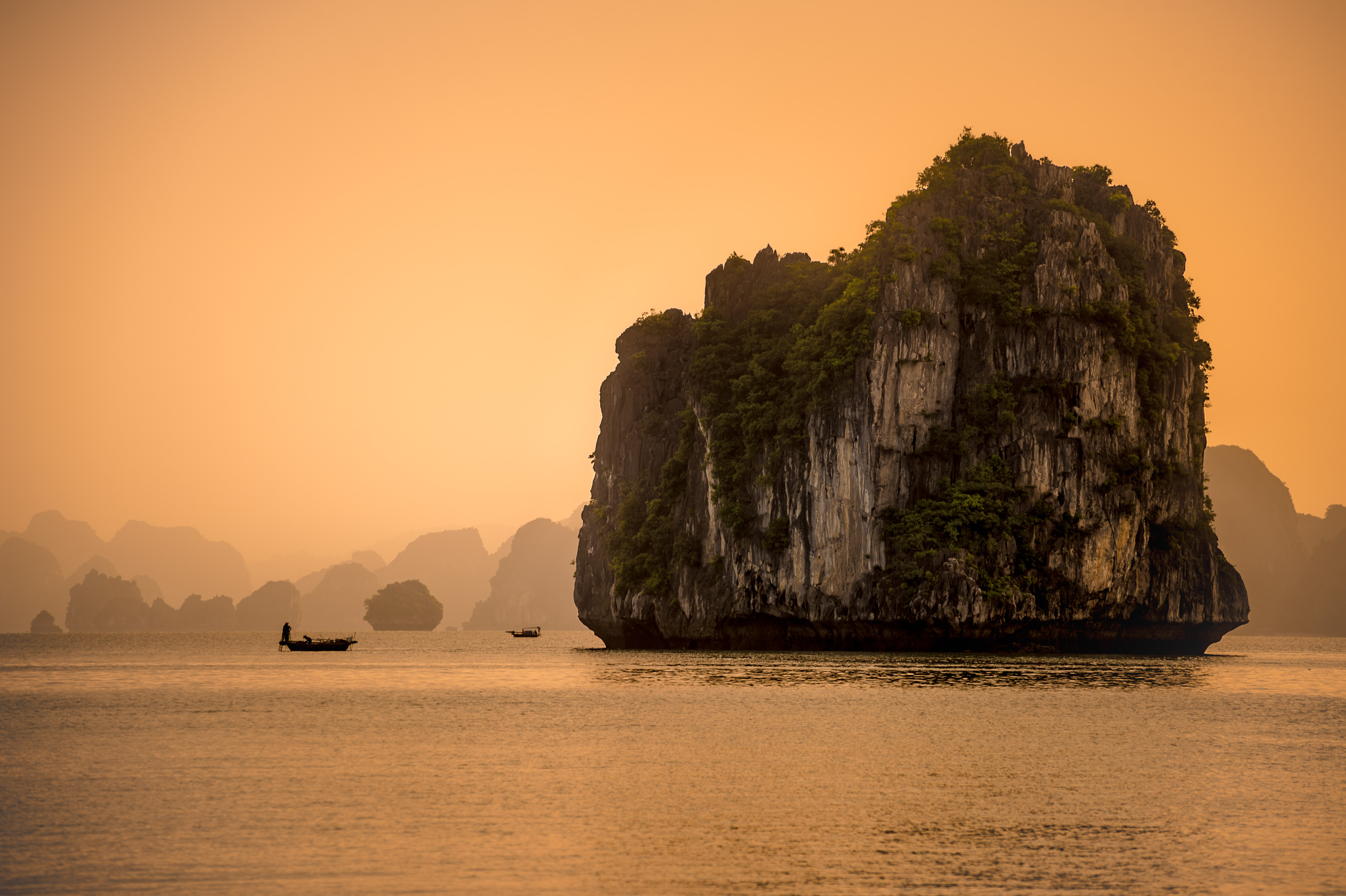 Asie du Sud-Est, Viêt Nam, golfe du Tonkin, Province de Quảng Ninh, Baie d'Ha-Long (Vịnh Hạ Long) inscrite au Patrimoine mondial de l'Unesco (1994), lever de soleil sur le paysage emblématique aux reliefs karstiques parcouru par les pêcheurs et leurs bateaux // Southeast Asia, Vietnam, Gulf of Tonkin, Quang Ninh province, Ha Long Bay (Vinh Ha Long) on the UNESCO World Heritage (1994), sunrise over the iconic landscape of karst landforms crossed by fishermen and their boats
