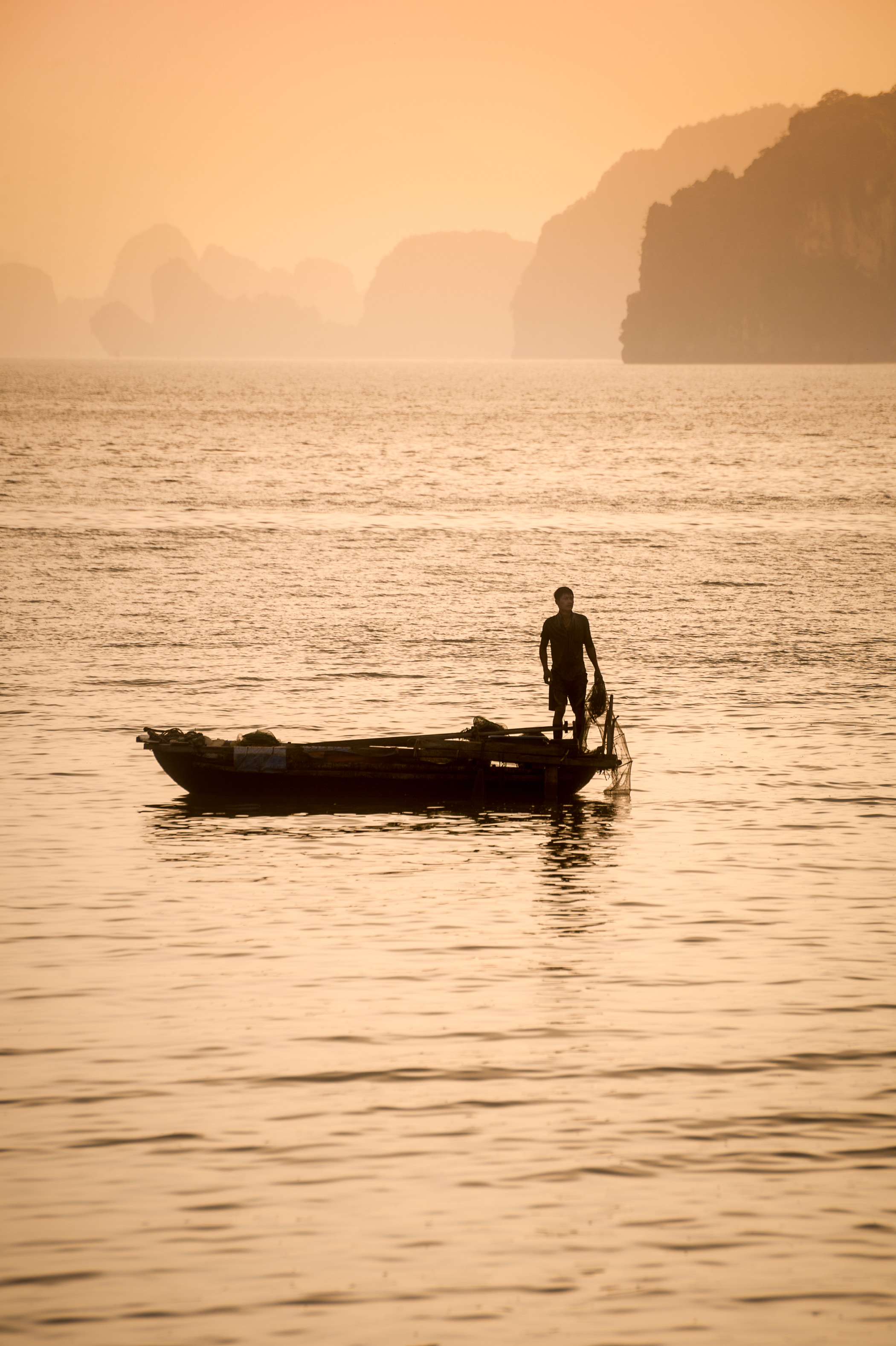 Asie du Sud-Est, Viêt Nam, golfe du Tonkin, Province de Quảng Ninh, Baie d'Ha-Long (Vịnh Hạ Long) inscrite au Patrimoine mondial de l'Unesco (1994), lever de soleil sur le paysage emblématique aux reliefs karstiques parcouru par les pêcheurs et leurs bateaux // Southeast Asia, Vietnam, Gulf of Tonkin, Quang Ninh province, Ha Long Bay (Vinh Ha Long) on the UNESCO World Heritage (1994), sunrise over the iconic landscape of karst landforms crossed by fishermen and their boats