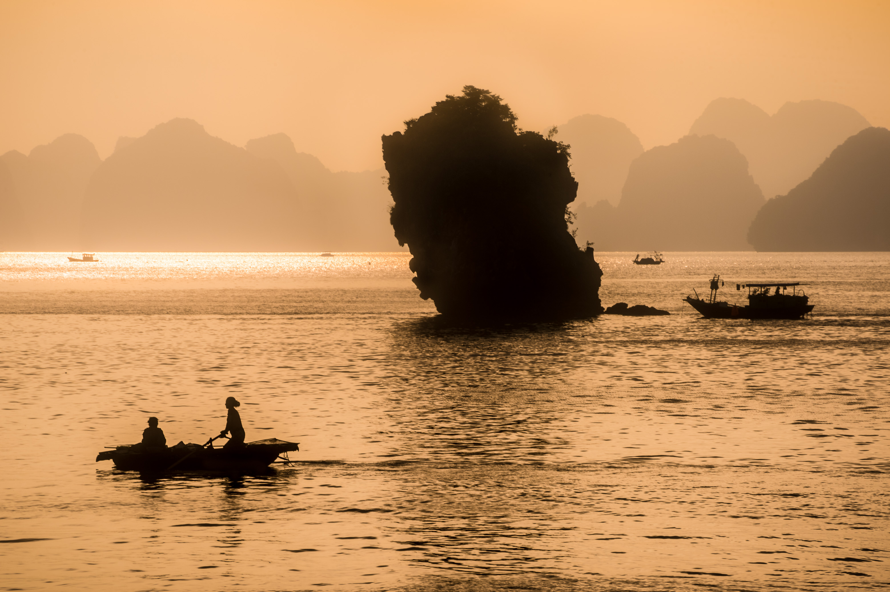 Asie du Sud-Est, Viêt Nam, golfe du Tonkin, Province de Quảng Ninh, Baie d'Ha-Long (Vịnh Hạ Long) inscrite au Patrimoine mondial de l'Unesco (1994), lever de soleil sur le paysage emblématique aux reliefs karstiques parcouru par les pêcheurs et leurs bateaux // Southeast Asia, Vietnam, Gulf of Tonkin, Quang Ninh province, Ha Long Bay (Vinh Ha Long) on the UNESCO World Heritage (1994), sunrise over the iconic landscape of karst landforms crossed by fishermen and their boats
