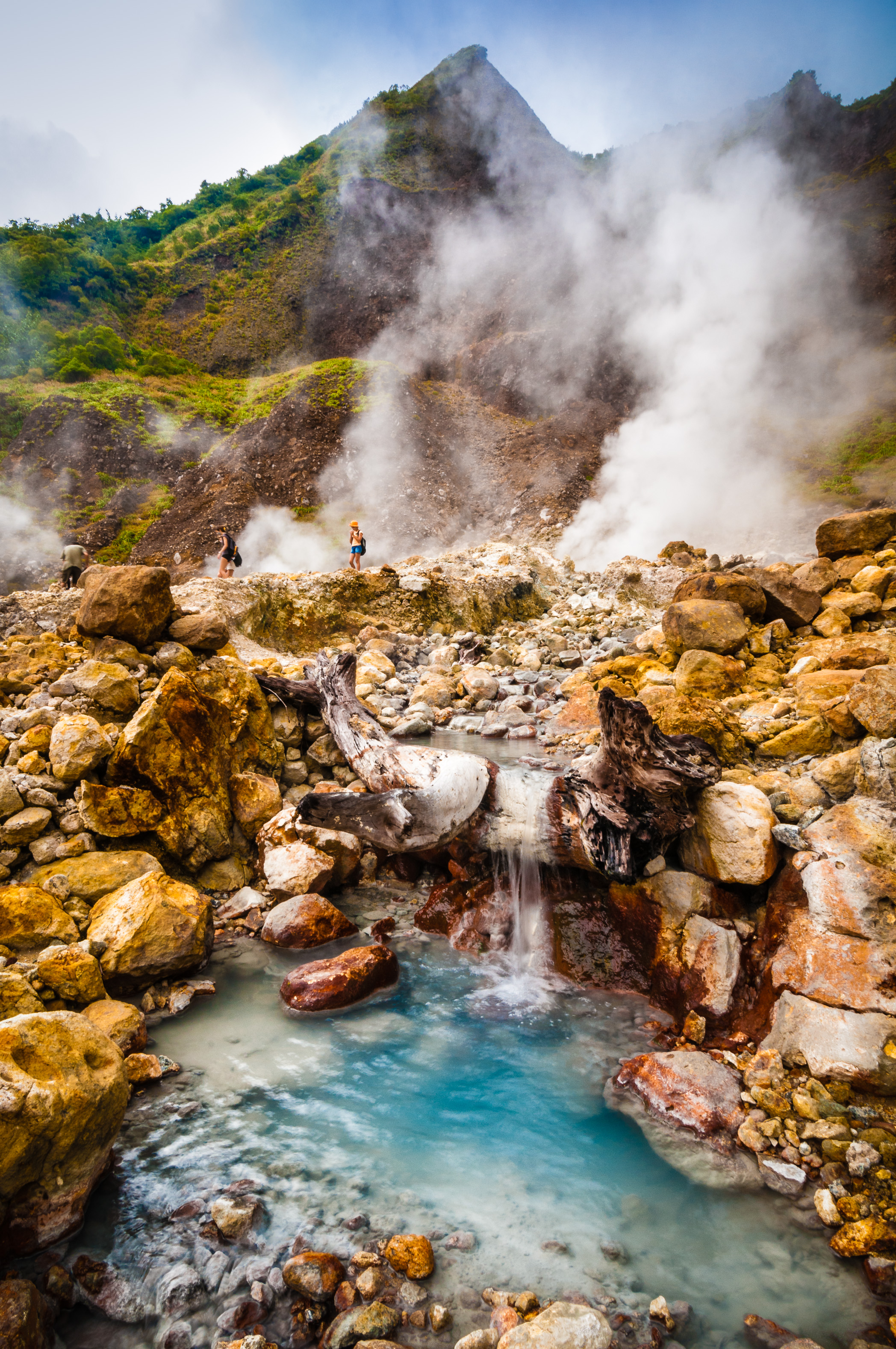 Group of trekkers in the Valley of Desolation among fumerolles and hot water in Dominica island / Groupe de randonneurs au milieu des fumerolles et sources d'eau chaude dans la Vallée de la Désolation, la Dominique, Caraïbes.