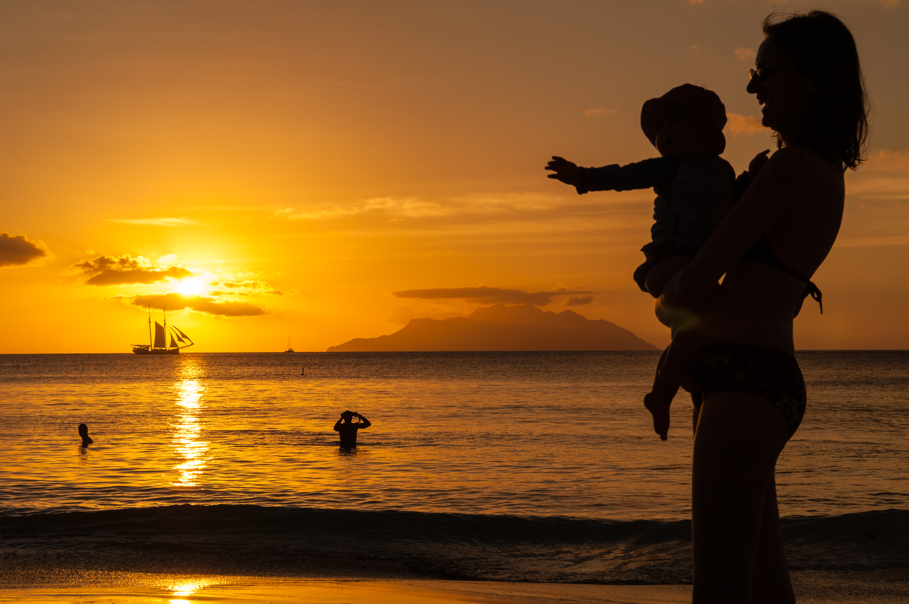Seychelles, océan Indien, île de Mahé, Beau Vallon, baignade au coucher de soleil, l'île de Silhouette et un voilier en ombre chinoise, depuis la plage de Beau Vallon // Seychelles, Indian Ocean, Mahe Island, Beau Vallon, swimming at sunset with Silhouette Island and a sailboat in background, from Beau Vallon beach