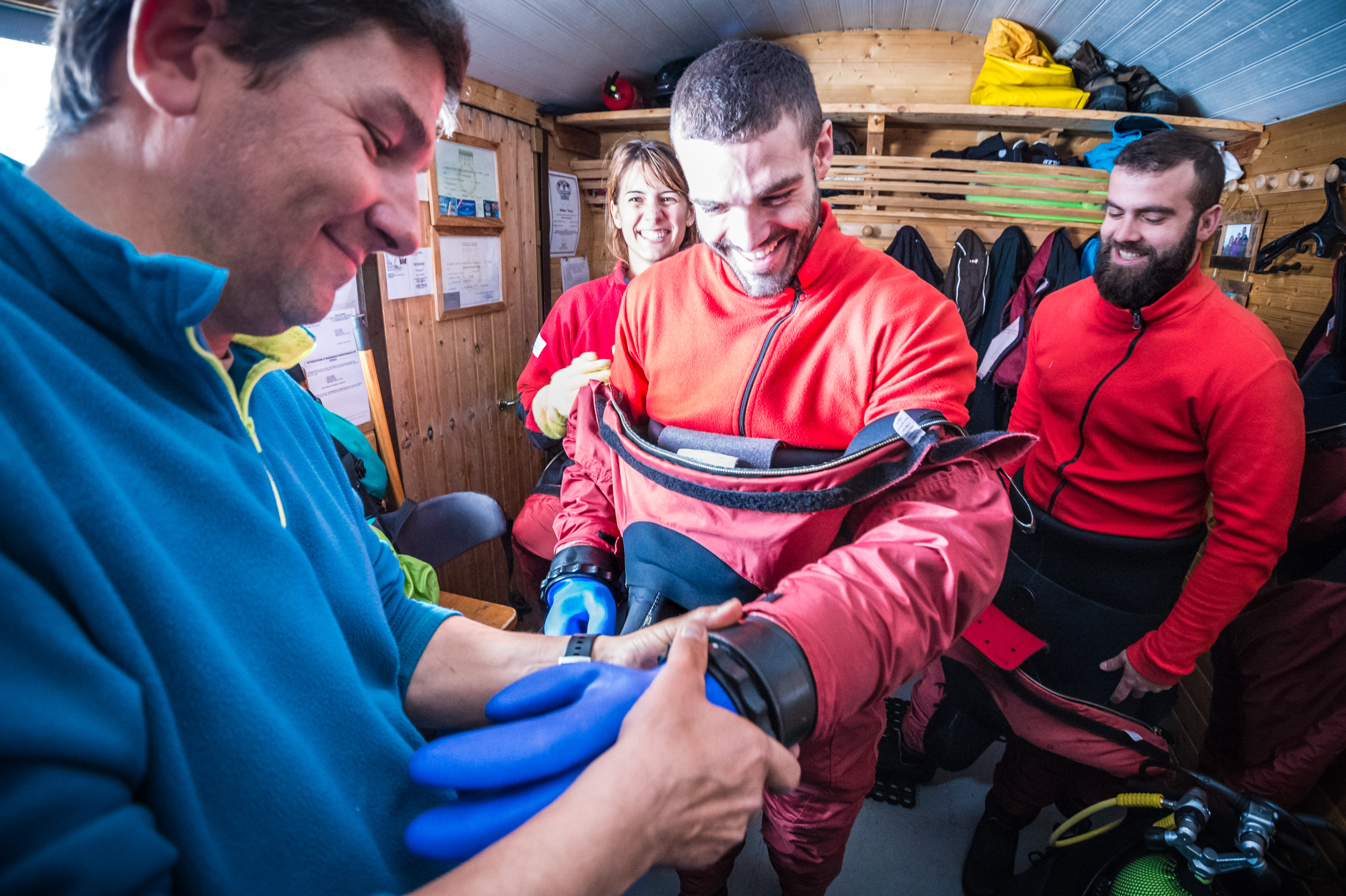 France, Isère (38), Belledonne, Chamrousse, lacs Robert, après la paire de gants en laine pour maintenir les mains à bonne température, un moniteur visse la paire de gants étanches sur la combinaison, avant une plongée sous glace - Dive Xtrême // France, Isère (38), Belledonne, Chamrousse, Robert Lakes, after the pair of wool gloves to keep the hands at good temperature, an instructor screws the pair of waterproof gloves on the suit, before an ice diving - Dive Xtreme